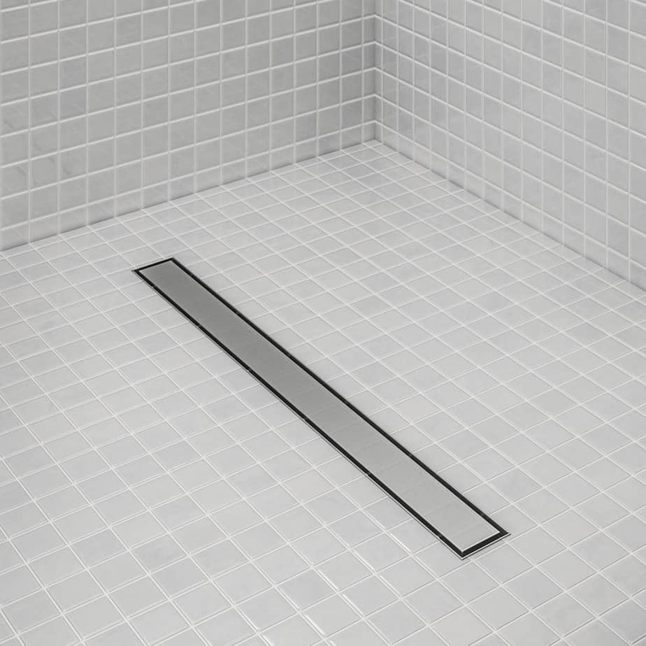 Bay 2-in-1 Linear Drain by QM Drain installed in a modern shower. Reversible grate design blends with tile floor, offering clean aesthetics and efficient water drainage.