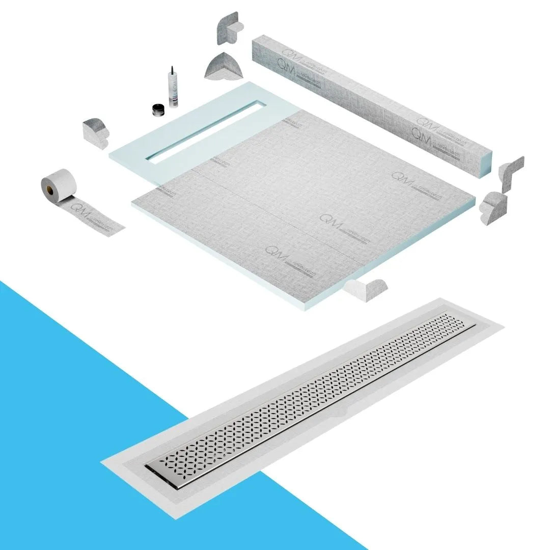 QM Drain Curb Shower Pan with Delmar Lotus Flange Edge Linear Drain, stainless-steel decorative floral grate design, integrated flange for seamless tile installation, efficient drainage, offered in Satin, Gold, Bronze, Polished, and Black finishes.