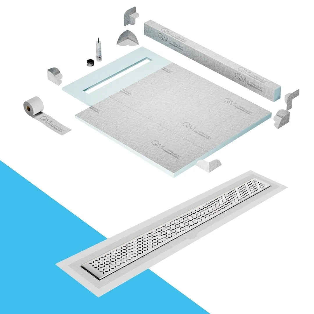 QM Drain Curb Shower Pan with Delmar Lotus Flange Edge Linear Drain, stainless-steel decorative floral grate design, integrated flange for seamless tile installation, efficient drainage, offered in Satin, Gold, Bronze, Polished, and Black finishes.