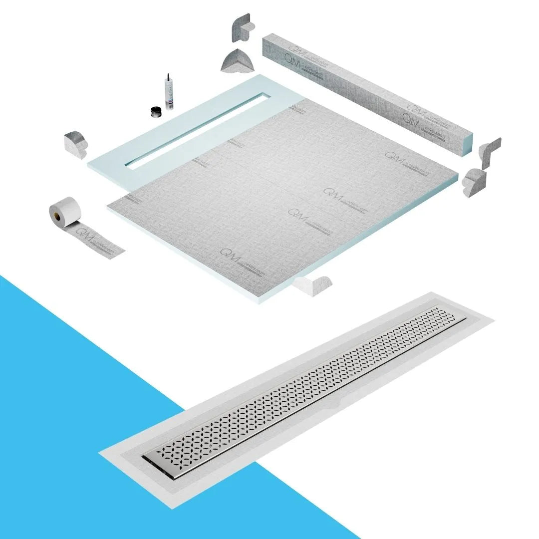 QM Drain Curb Shower Pan with Delmar Lotus Flange Edge Linear Drain, stainless-steel decorative floral grate design, integrated flange for seamless tile installation, efficient drainage, offered in Satin, Gold, Bronze, Polished, and Black finishes.