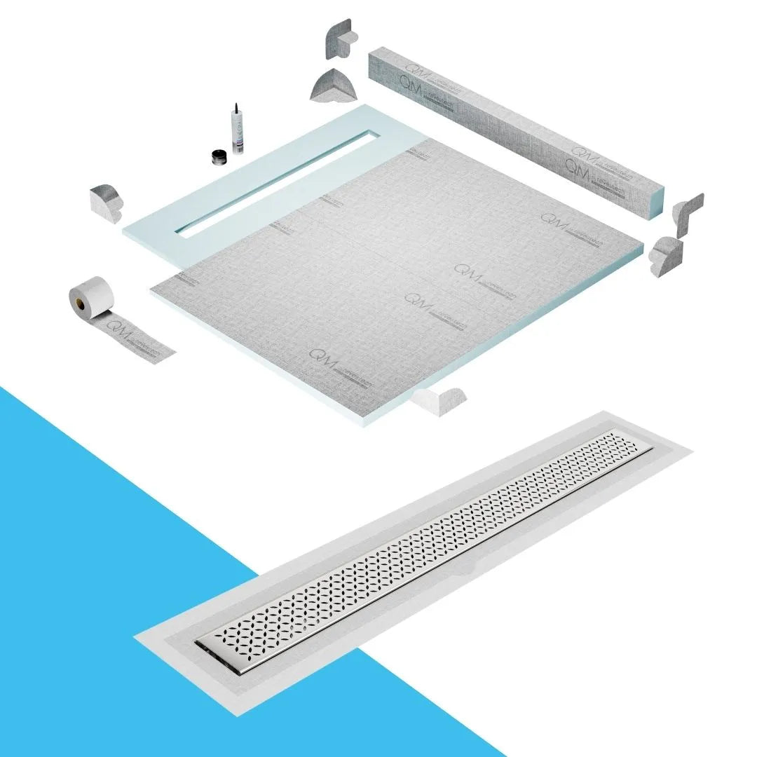 QM Drain Curb Shower Pan with Delmar Lotus Flange Edge Linear Drain, stainless-steel decorative floral grate design, integrated flange for seamless tile installation, efficient drainage, offered in Satin, Gold, Bronze, Polished, and Black finishes.