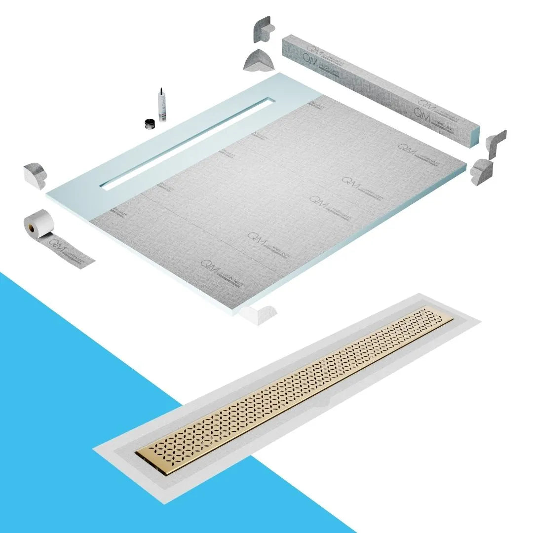 QM Drain Curb Shower Pan with Delmar Lotus Flange Edge Linear Drain, stainless-steel decorative floral grate design, integrated flange for seamless tile installation, efficient drainage, offered in Satin, Gold, Bronze, Polished, and Black finishes.