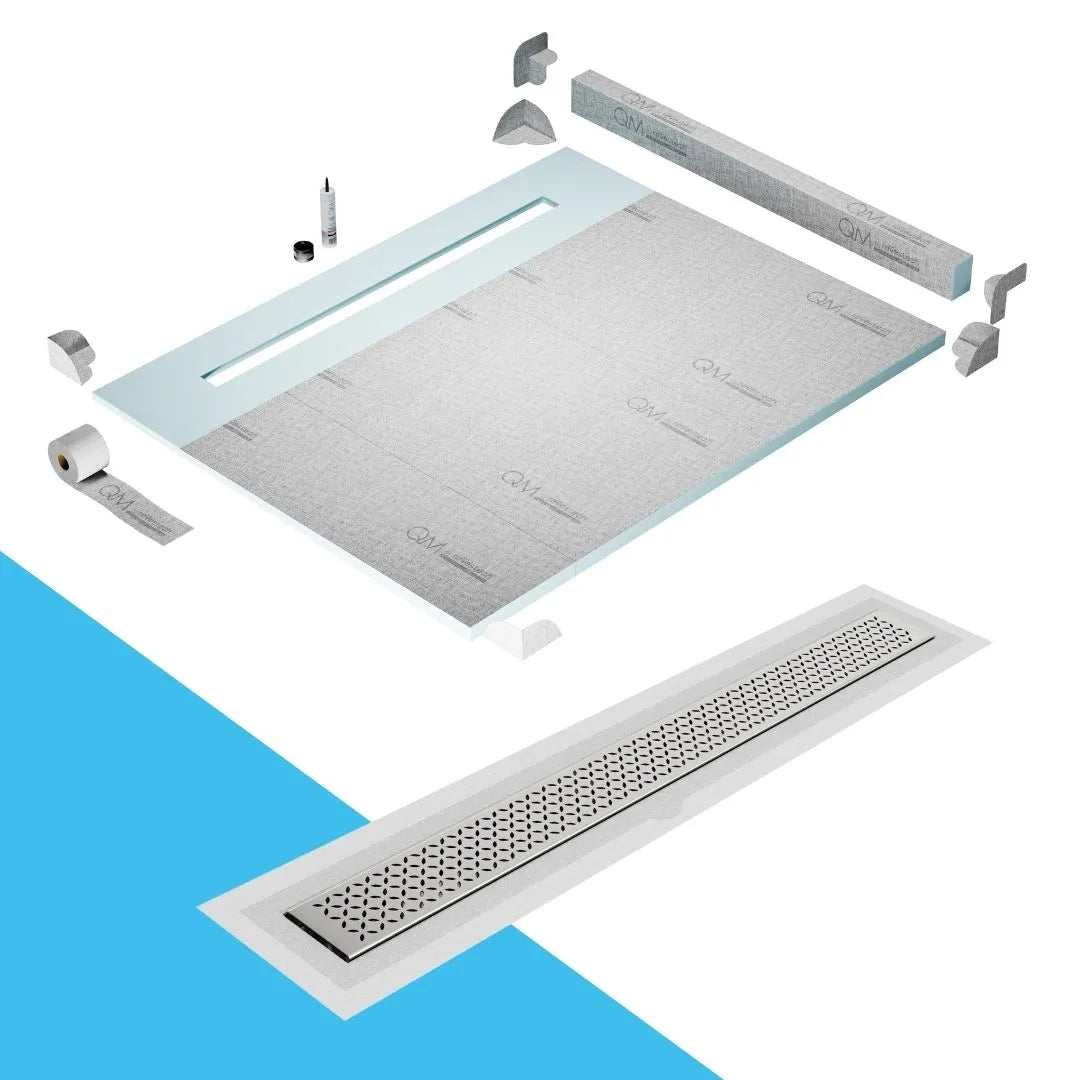 QM Drain Curb Shower Pan with Delmar Lotus Flange Edge Linear Drain, stainless-steel decorative floral grate design, integrated flange for seamless tile installation, efficient drainage, offered in Satin, Gold, Bronze, Polished, and Black finishes.