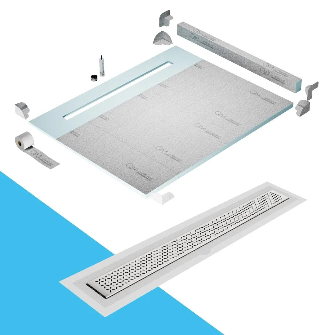 QM Drain Curb Shower Pan with Delmar Lotus Flange Edge Linear Drain, stainless-steel decorative floral grate design, integrated flange for seamless tile installation, efficient drainage, offered in Satin, Gold, Bronze, Polished, and Black finishes.