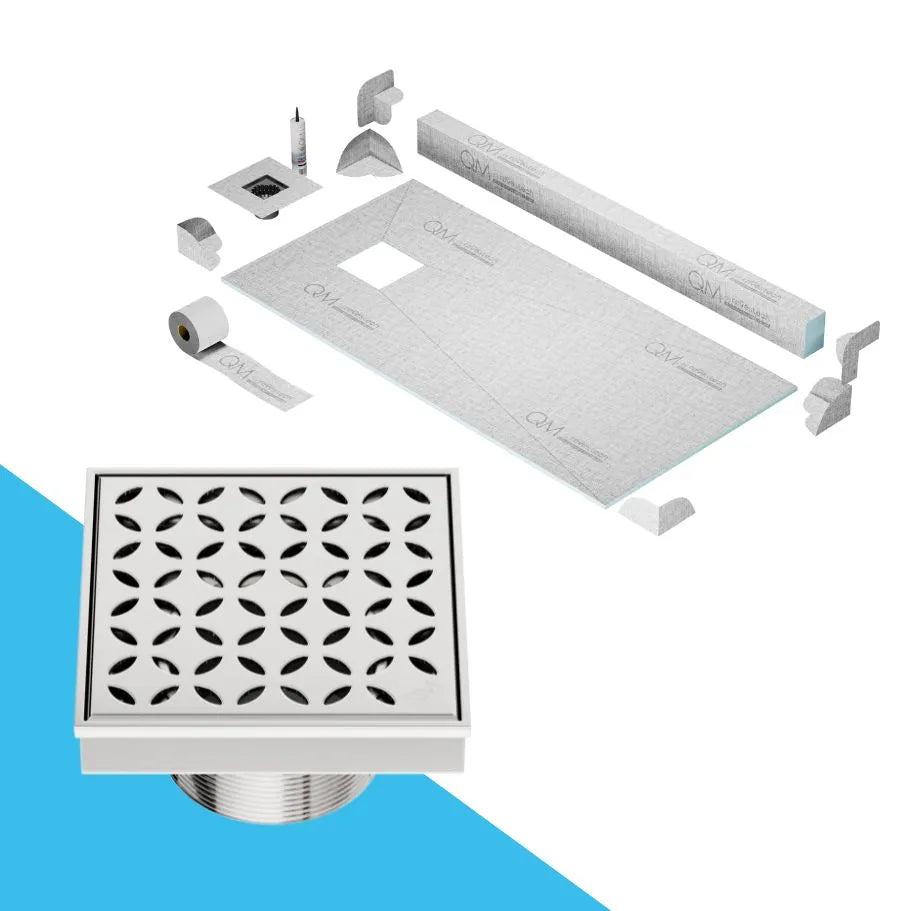 QM Drain curb Shower Pan with Delmar Lotus Off-Center Square Drain, elegant floral-pattern stainless-steel grate, stylish, efficient drainage, offered in Satin, Gold, Bronze, Polished, and Black finishes.