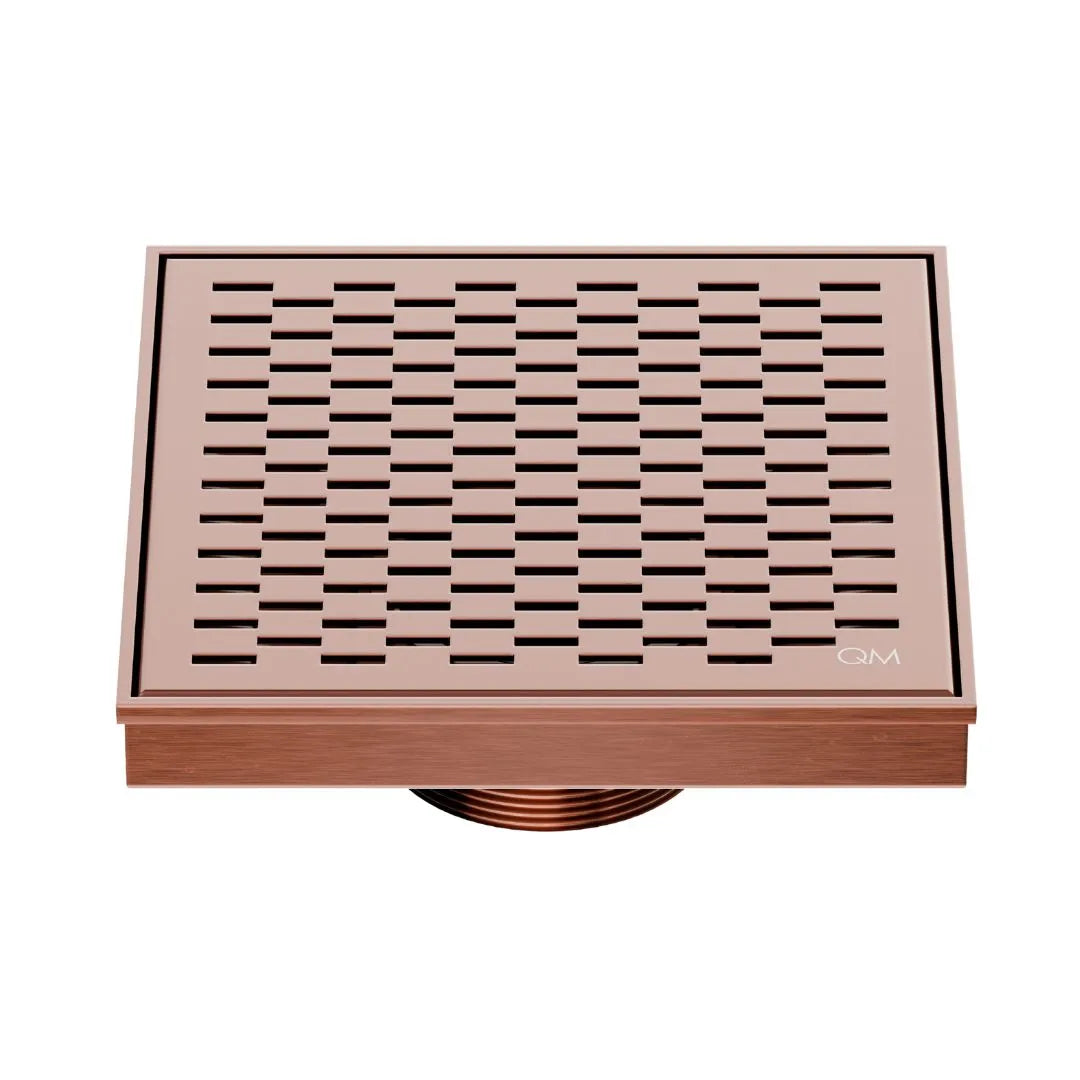 QM Drain Delmar Delta Square Drain 5 3/4-inch in Bronze finish, featuring a sleek stainless-steel square-pattern grate. This drain provides efficient water drainage, seamless tile integration, and an elegant, modern design, ideal for luxury shower and bathroom floor installations.