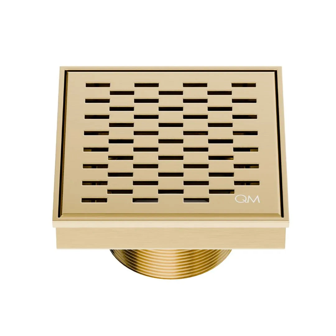M Drain Delmar Delta Square Drain 4x4-inch in Gold finish, featuring a sleek stainless-steel square-pattern grate. This drain ensures efficient water drainage, seamless tile integration, and a luxurious aesthetic, ideal for high-end shower and bathroom floor installations.