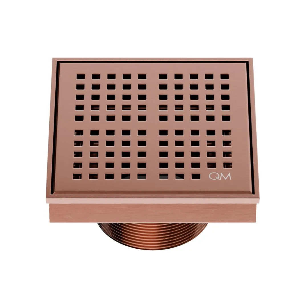 QM Drain Delmar Kai Square Drain 4x4-inch in Bronze finish, featuring a sleek stainless-steel grate with fine square perforations. This drain provides efficient water drainage, seamless tile integration, and an elegant aesthetic, ideal for luxury shower and bathroom floor installations.