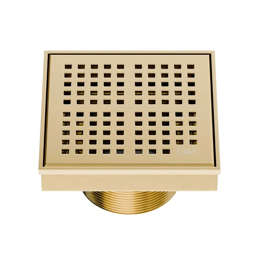 QM Drain Delmar Kai Square Drain 4x4-inch in Gold finish, featuring a sleek stainless-steel grate with fine square perforations. This drain ensures efficient water drainage, seamless tile integration, and a luxurious aesthetic, perfect for high-end shower and bathroom floor installations.