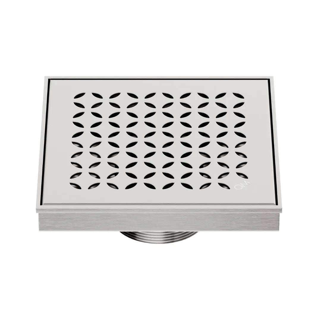 QM Drain Delmar Lotus Square Drain 5 3/4-inch in Satin finish, featuring a sleek stainless-steel channel with an elegant floral-pattern grate. This drain offers efficient water drainage, seamless tile integration, and a high-end polished aesthetic, ideal for luxury shower and bathroom floor installations.