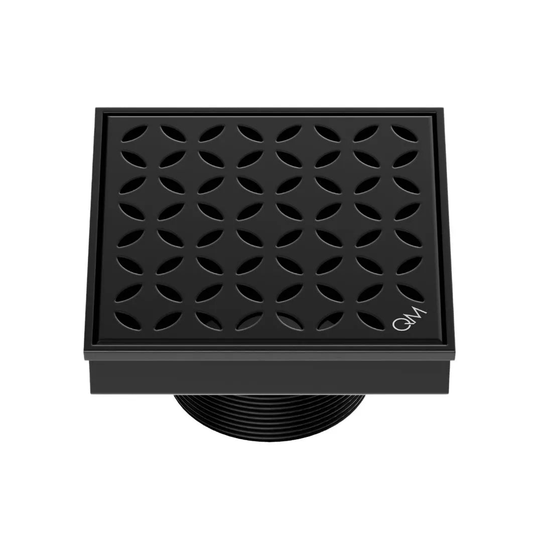 QM Drain Delmar Lotus Square Drain 4x4-inch in Black finish, featuring a sleek stainless-steel channel with an elegant floral-pattern grate. This drain ensures efficient water drainage, seamless tile integration, and a modern minimalist aesthetic, ideal for luxury shower and bathroom floor installations.