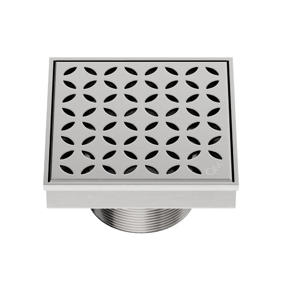 QM Drain Delmar Lotus Square Drain 4x4-inch in Satin finish, featuring a sleek stainless-steel channel with an elegant floral-pattern grate. This drain offers efficient water drainage, seamless tile integration, and a high-end polished aesthetic, ideal for luxury shower and bathroom floor installations.