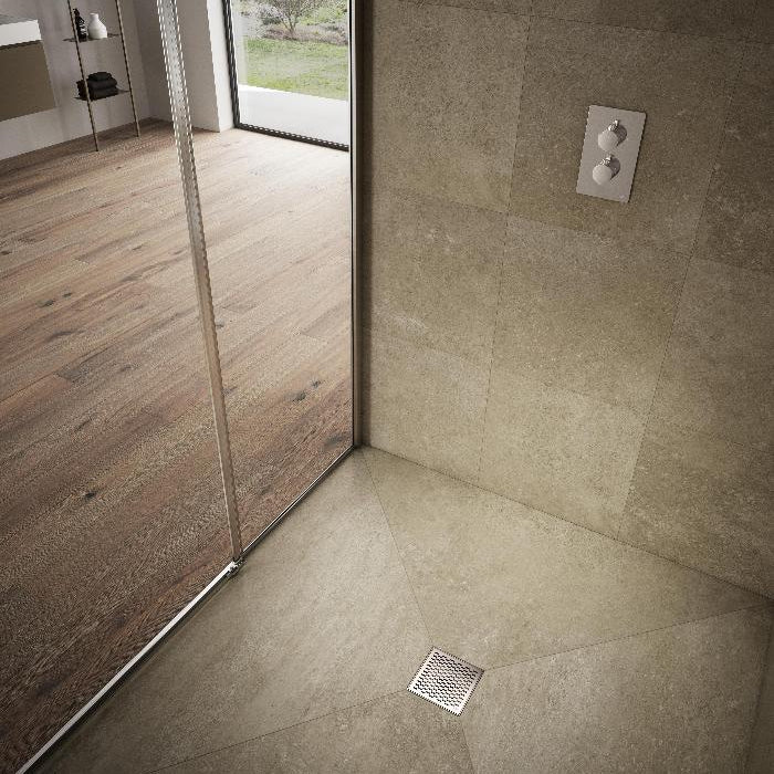 QM Drain Delmar Delta Square Drain installed in a modern bathroom, featuring a sleek stainless-steel square-pattern grate. This image highlights seamless tile integration and efficient water drainage, offering a contemporary and minimalist aesthetic for luxury shower and bathroom floor installations.