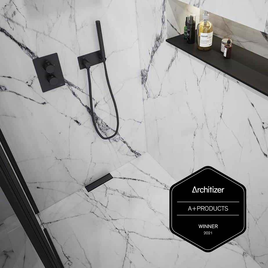 Luxury bathroom featuring a high-end design recognized with the Architizer A+ Products Winner 2021 seal. The image showcases elegant fixtures, including a sleek linear drain, seamless tile integration, and a modern, minimalist aesthetic, ideal for contemporary luxury shower and bathroom installations.