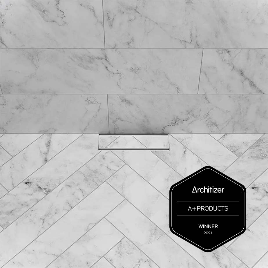Stunning luxury bathroom featuring design elements awarded the Architizer A+ Products Winner 2021 seal. This bathroom showcases sleek fixtures, including a modern linear drain, seamless tile integration, and a minimalist, elegant aesthetic, creating the perfect environment for high-end shower and bathroom installations.