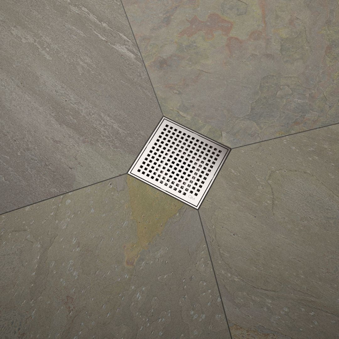 QM Drain Lagos Mira Square Drain, featuring a sleek stainless-steel square design with a fine perforated grate. This image highlights the drain's efficient water drainage and seamless integration with modern tile floors, ideal for luxury bathroom and shower installations.
