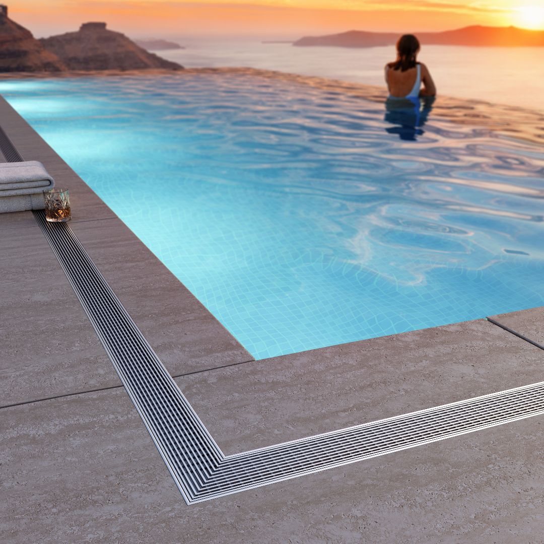 Modern outdoor pool deck featuring the Wedgewire Outdoor Pool Linear Drain installed along the water’s edge, highlighting its corrosion-resistant stainless-steel construction, high-flow wedge-wire grate, and seamless integration for efficient surface drainage.