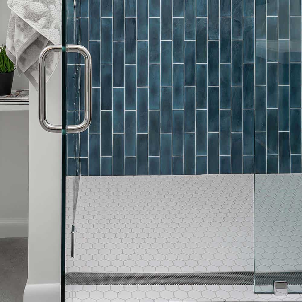 Modern shower installation featuring the Perforated Adjustable Lagos Linear Drain with 2″ outlet set into large-format stone tiles, highlighting its corrosion-resistant stainless-steel construction, customizable length, and efficient water evacuation in a luxury bathroom setting