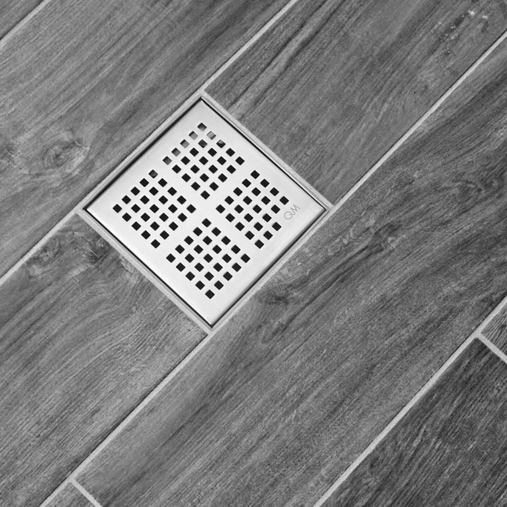 QM Drain Delmar Kai Square Drain installed in a modern bathroom, featuring a sleek stainless-steel grate with fine square perforations. This image highlights seamless tile integration and efficient water drainage, offering a contemporary and minimalist aesthetic for luxury shower and bathroom floor installations.
