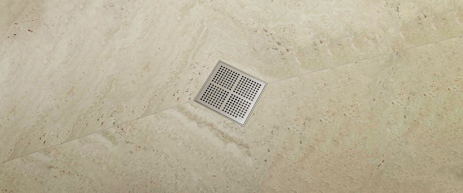 Banner featuring a Kai center shower drain installed in a modern bathroom floor, highlighting the elegant square design and premium stainless steel finish.