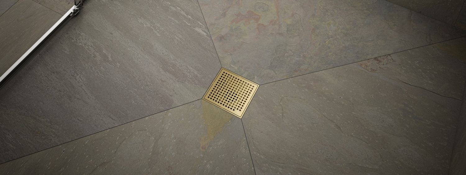 Banner featuring a Lagos center shower drain installed in a bathroom floor, showcasing its square stainless steel design, durable build, and modern aesthetic by QM Drain.