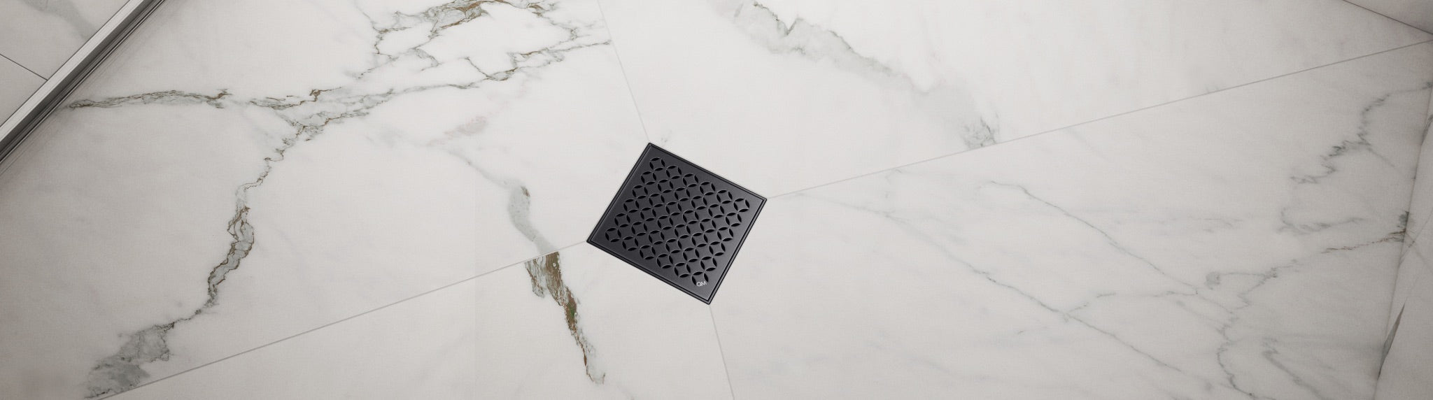 Banner featuring a center shower drain installed in a modern bathroom floor, showcasing durable stainless steel construction and a minimalist design from QM Drain.