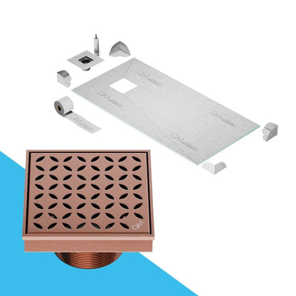QM Drain Curbless Shower Pan with Delmar Lotus Off Center Square Drain, stainless-steel floral-pattern grate, available in Satin, Gold, Bronze, Polished, and Black finishes, offering elegant aesthetics and effective water drainage for luxury bathrooms.