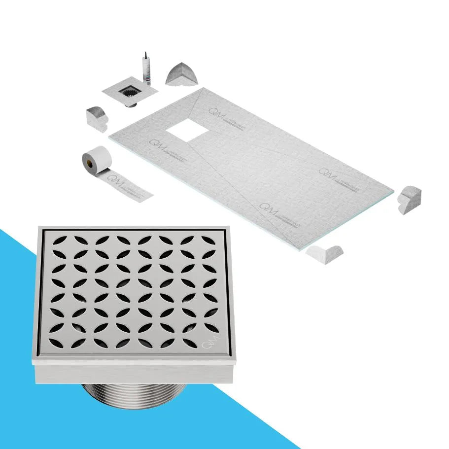 QM Drain Curbless Shower Pan with Delmar Lotus Off Center Square Drain, stainless-steel floral-pattern grate, available in Satin, Gold, Bronze, Polished, and Black finishes, offering elegant aesthetics and effective water drainage for luxury bathrooms.
