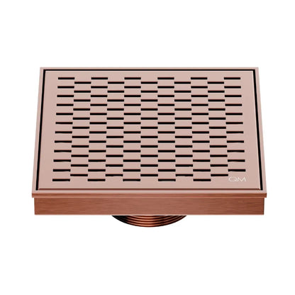 QM Drain Delmar Delta Square Drain 5 3/4-inch in Bronze finish, featuring a sleek stainless-steel square-pattern grate. This drain provides efficient water drainage, seamless tile integration, and an elegant, modern design, ideal for luxury shower and bathroom floor installations.