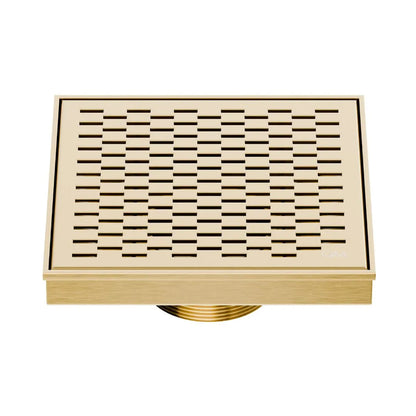 QM Drain Delmar Delta Square Drain 5 3/4-inch in Gold finish, featuring a sleek stainless-steel square-pattern grate. This drain ensures efficient water drainage, seamless tile integration, and a luxurious aesthetic, perfect for high-end shower and bathroom floor installations.