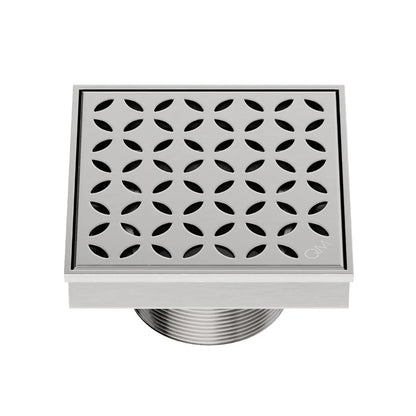 QM Drain Delmar Lotus Square Drain 4x4-inch in Satin finish, featuring a sleek stainless-steel channel with an elegant floral-pattern grate. This drain offers efficient water drainage, seamless tile integration, and a high-end polished aesthetic, ideal for luxury shower and bathroom floor installations.