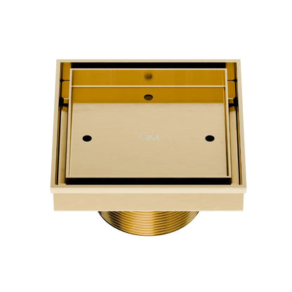 QM Drain Delmar Mist Tile-In Square Shower Drain 4x4-inch in Gold finish, featuring a sleek stainless-steel channel with a 'mist' perforated grate design. This drain allows seamless tile integration, offering efficient water drainage and a luxurious aesthetic for high-end shower and bathroom floor installations.
