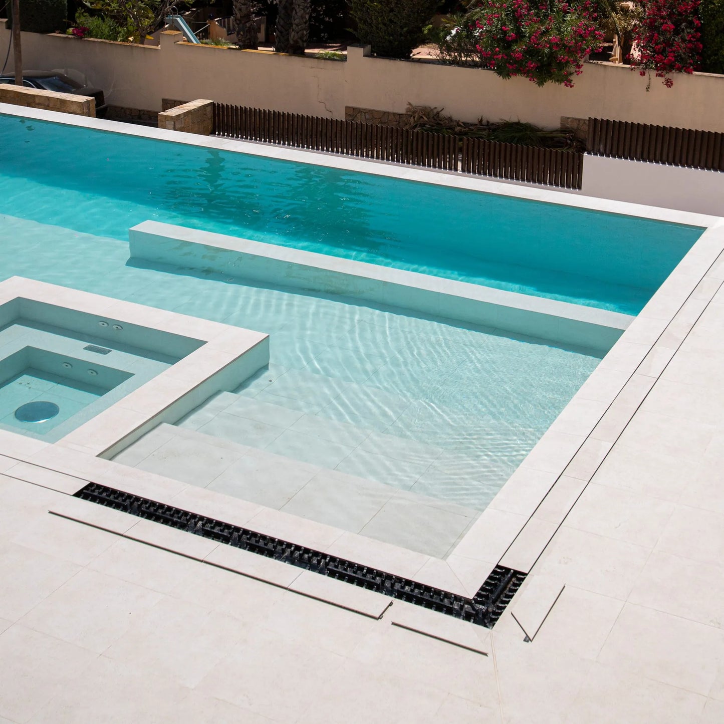 QM Drain Invisible Modular Linear Drain System installed in a deck, providing seamless integration for efficient water drainage. This system is designed for modern outdoor spaces, offering a sleek and minimalist aesthetic while ensuring optimal performance in luxury poolside or patio installations.