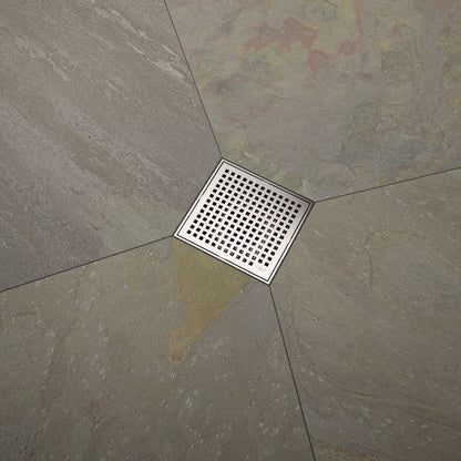 QM Drain Lagos Mira Square Drain, featuring a sleek stainless-steel square design with a fine perforated grate. This image highlights the drain's efficient water drainage and seamless integration with modern tile floors, ideal for luxury bathroom and shower installations.