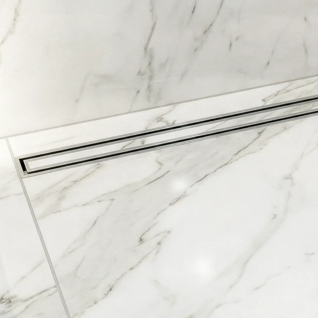 A stunning luxury walk-in shower featuring the QM Drain Lagos Mist Couture adjustable linear drain. The tile-in design creates a seamless floor appearance that integrates perfectly with large-format porcelain tiles for a clean, modern bathroom aesthetic.