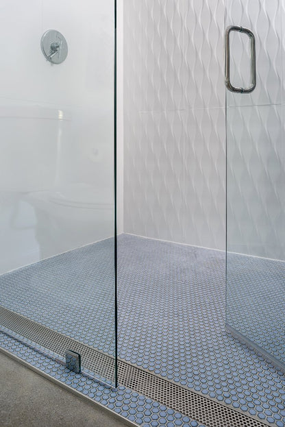 Perforated Adjustable Delmar Linear Drain in a commercial setting with white oak wood flooring. Stainless-steel channel with precision perforated grate, adjustable frame, and integrated flange for efficient, high-capacity drainage and seamless integration into the floor design.