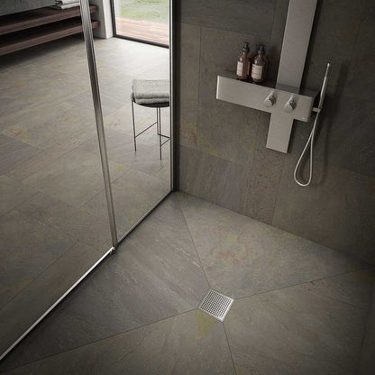 Modern shower floor showcasing the QM Drain Mira Square Drain in Satin finish—4″×4″ stainless-steel tile-insert grate with subtle curved slots, integrated waterproof flange, and efficient high-flow drainage for sleek, contemporary bathroom designs.