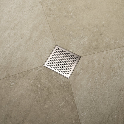 QM Drain Delmar Delta Square Drain installed in a luxury bathroom, showcasing a sleek stainless-steel square-pattern grate. The image highlights efficient water drainage, seamless tile integration, and a modern, minimalist design that complements high-end shower and bathroom installations.