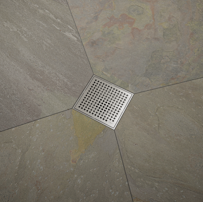 QM Drain Lagos Mira Square Drain, featuring a sleek stainless-steel square design with a fine perforated grate. This image highlights the drain's efficient water drainage and seamless integration with modern tile floors, ideal for luxury bathroom and shower installations.